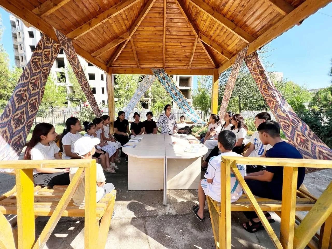 Atlas matolar bilan bezatilgan shiyponda ochiq havodagi dars