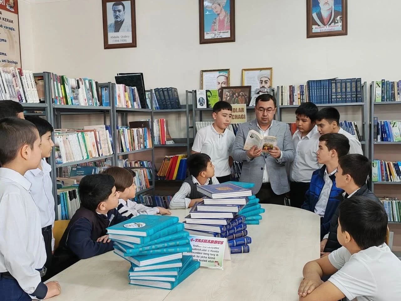 Kutubxonada ustoz oʻquvchilarga kitob oʻqib bermoqda
